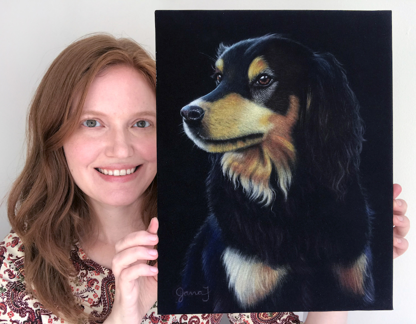 Redheaded woman holding a painting of a dog